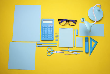 Blue Stationery set on yellow background. Back to school, education, office supplies. Flat lay. Top view. Creative layoutの写真素材