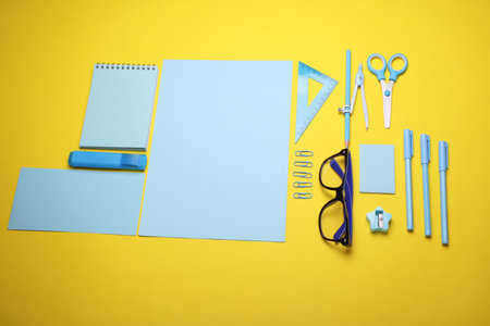 Blue Stationery set on yellow background. Back to school, education, office supplies. Flat lay. Top view. Creative layoutの写真素材