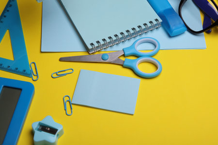 Blue Stationery set on yellow background. Back to school, education, office supplies. Flat lay. Top view. Creative layoutの写真素材