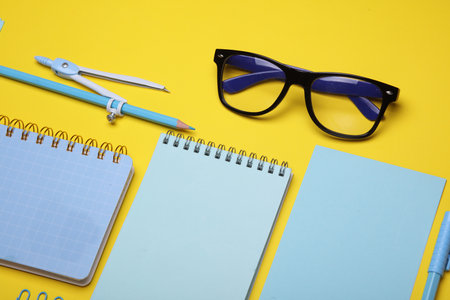 Blue Stationery set on yellow background. Back to school, education, office supplies. Flat lay. Top view. Creative layoutの写真素材