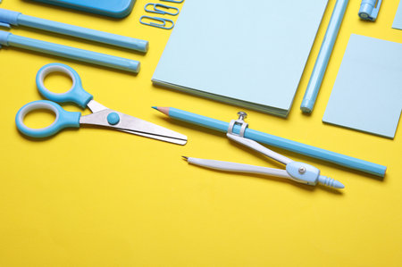 Blue Stationery set on yellow background. Back to school, education, office supplies. Flat lay. Top view. Creative layoutの写真素材