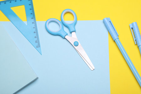 Blue Stationery set on yellow background. Back to school, education, office supplies. Flat lay. Top view. Creative layoutの写真素材