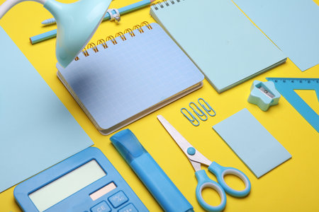 Blue Stationery set on yellow background. Back to school, education, office supplies. Flat lay. Top view. Creative layoutの写真素材