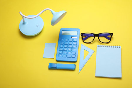 Blue Stationery set on yellow background. Back to school, education, office supplies. Flat lay. Top view. Creative layoutの写真素材