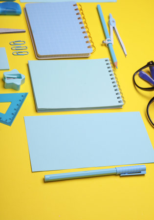Blue Stationery set on yellow background. Back to school, education, office supplies. Flat lay. Top view. Creative layoutの写真素材
