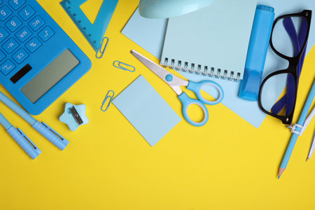 Blue Stationery set on yellow background. Back to school, education, office supplies. Flat lay. Top view. Creative layoutの写真素材