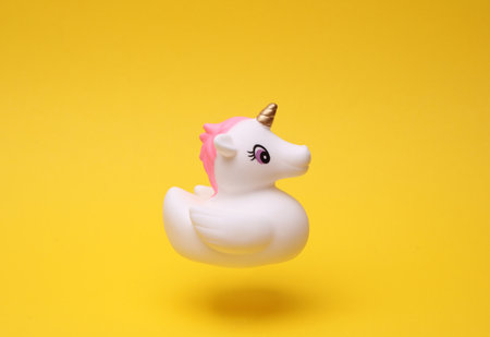 Rubber bath unicorn floating on yellow background.の写真素材