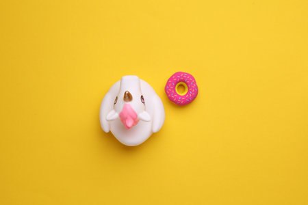 Rubber bath unicorn with donut on a yellow background. Top view.の写真素材