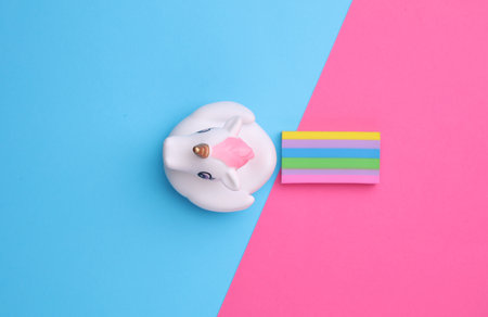 Rubber unicorn with rainbow on pink blue background. Creative ideaの写真素材