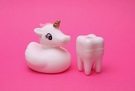Rubber unicorn with tooth on pink backgroundの写真素材