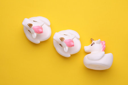 Rubber bath unicorns on a yellow background. Top view. Creative layoutの写真素材