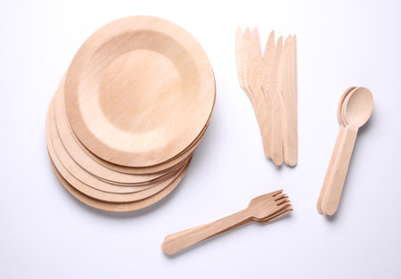 Set of wooden eco dishes on a white background. Plates, forks, knives and spoonsの写真素材