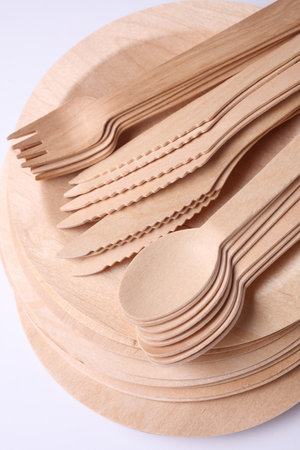 Set of wooden eco dishes on a white background. Plates, forks, knives and spoonsの写真素材