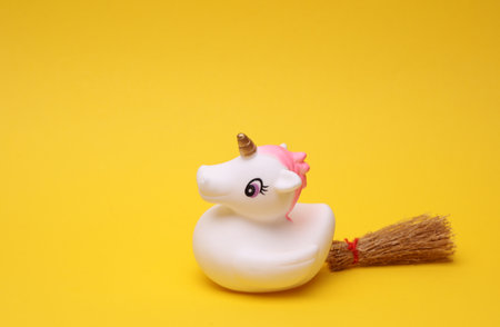 Rubber bath unicorn with halloween decor on a yellow background. Top view.