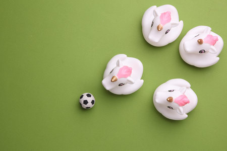 Rubber bath unicorns with soccer ball on green background. Top view. Sports conceptの写真素材