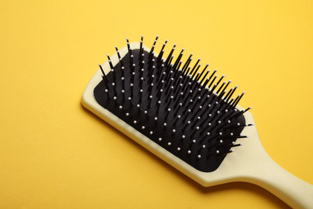 Hair brush, plastic comb on yellow backgroundの写真素材