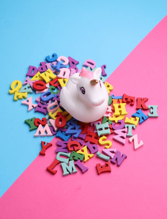 Rubber bath unicorn with multi-colored letters on pink blue backgroundの写真素材