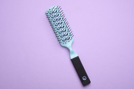 Hair brush, plastic comb on purple backgroundの写真素材