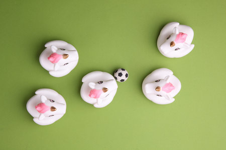 Rubber bath unicorns with soccer ball on green background. Top view. Sports conceptの写真素材