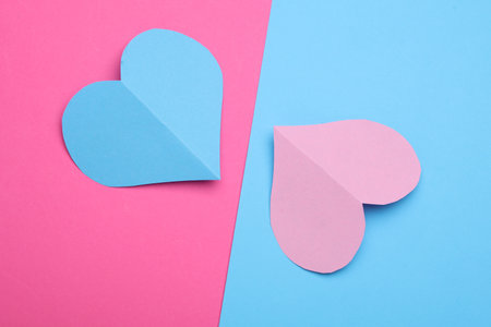 Paper hearts on a blue and pink background. Love conceptの写真素材