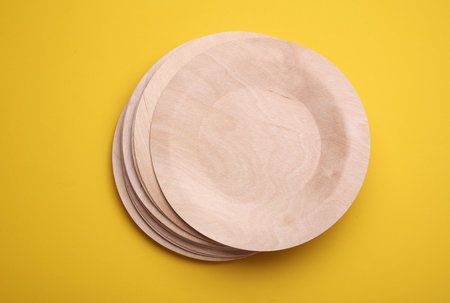 Eco wooden plates on yellow backgroundの写真素材