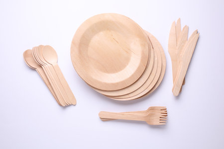 Set of wooden eco dishes on a white background. Plates, forks, knives and spoonsの写真素材
