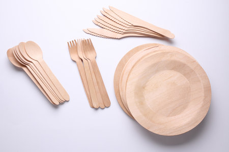 Set of wooden eco dishes on a white background. Plates, forks, knives and spoonsの写真素材