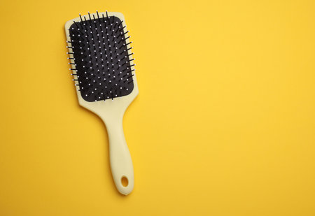 Hair brush, plastic comb on yellow backgroundの写真素材