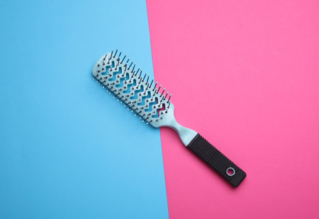Hair brush, plastic comb on pink blue backgroundの写真素材