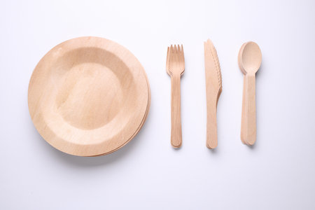 Set of wooden eco dishes on a white background. Plates, forks, knives and spoonsの写真素材