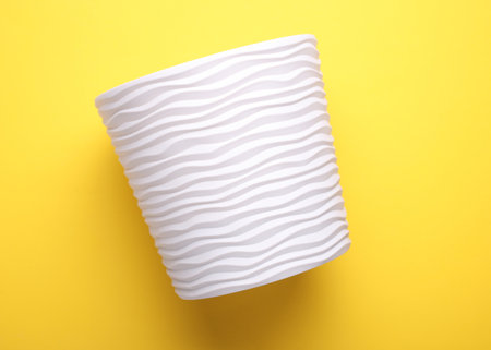 One plastic flowerpot on yellow backgroundの写真素材
