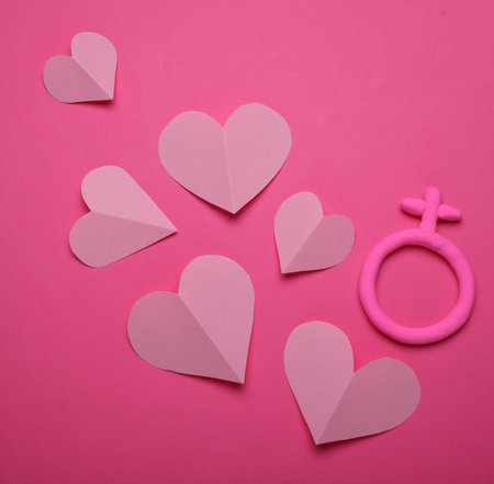 Female gender symbol made of plasticine and hearts on pink backgroundの写真素材