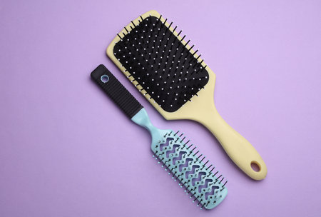 Two Hair brushes, plastic combs on purple backgroundの写真素材