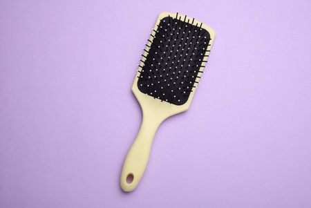 Hair brush, plastic comb on purple backgroundの写真素材