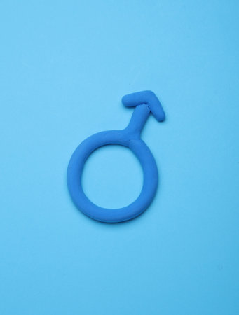 Male gender symbol made of plasticine on blue backgroundの写真素材