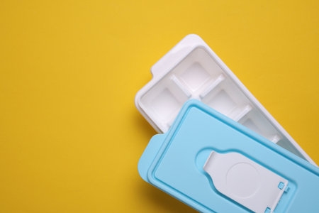 Plastic Ice Cube Maker Tray on Yellow Backgroundの写真素材