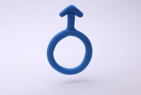 Blue Male gender symbol made of plasticine on blue backgroundの写真素材