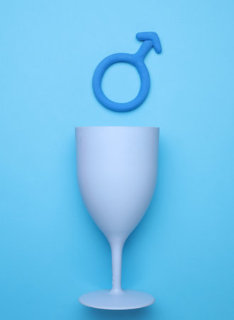 Plastic glass with male gender symbol on blue backgroundの写真素材