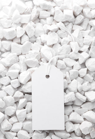 White price tag on white pebblesの写真素材