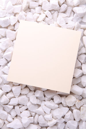 White card close up on pebbles. Mockup for designの写真素材