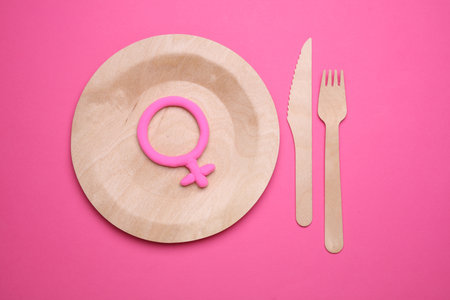 Wooden plate with female gender symbol on pink backgroundの写真素材