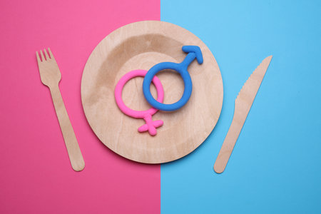 Wooden plate with female and male gender symbols on pink blue backgroundの写真素材