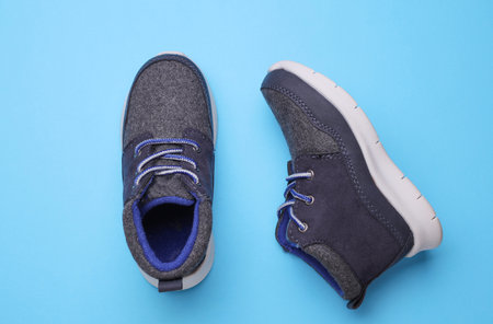 Children's warm sneakers half-boots on a blue backgroundの写真素材