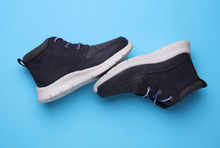 Children's warm sneakers half-boots on a blue backgroundの写真素材