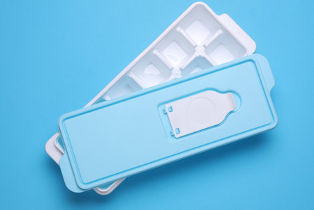 Plastic Ice Cube Maker Tray on Blue Backgroundの写真素材