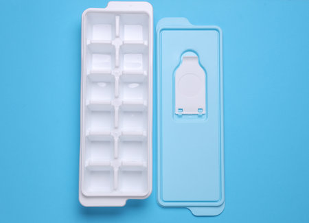 Plastic Ice Cube Maker Tray on Blue Backgroundの写真素材