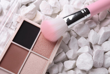 Makeup eyeshadow palette with brush on pebblesの写真素材