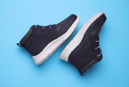 Children's warm sneakers half-boots on a blue backgroundの写真素材