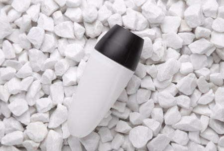 White antiperspirant stick tube on pebbles close up