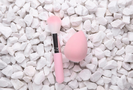 Makeup brush and foundation blender on white pebblesの写真素材